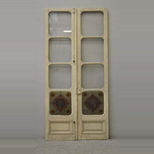 Двустворчатая дверь с витражами с медальонами, в которые вписаны мужской и женский профили.