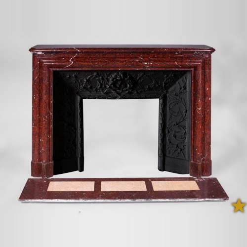 Старинный камин в стиле Людовика XIV, изготовленный из мрамора красный Гриотт, с чугунной внутренней вставкой.