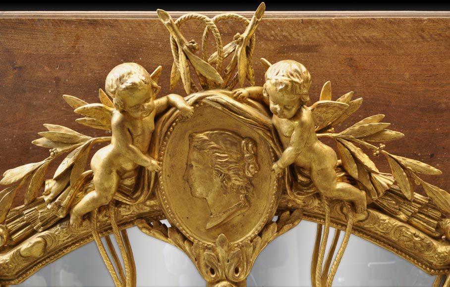 Великолепное зеркало с перегородками в стиле Наполеона III из дерева и позолоченного стюка, украшенное амурчиками и медальонами с женскими профилями. -1